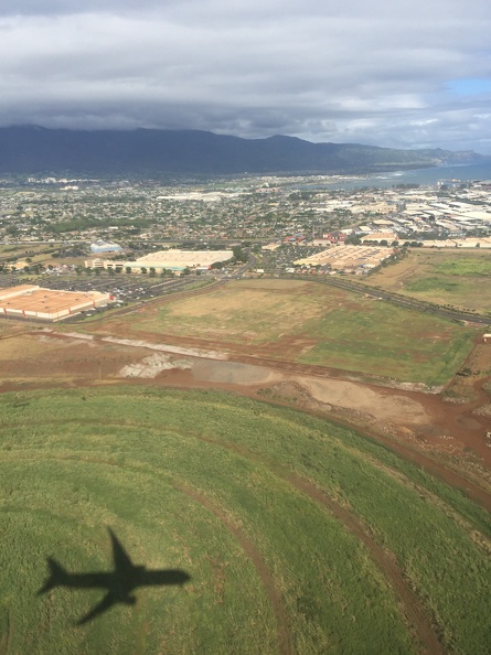 Flying above the Central Box Plant in Puunene, Kahului, Maui. Bottom left is the shadow of the Hawaiian Airlines jet I was on, and in the upper portion, left to right, are a Target, Home Depot, and Walmart. (I apologize if that last part ruins the mystique.) IMG_7168.JPG